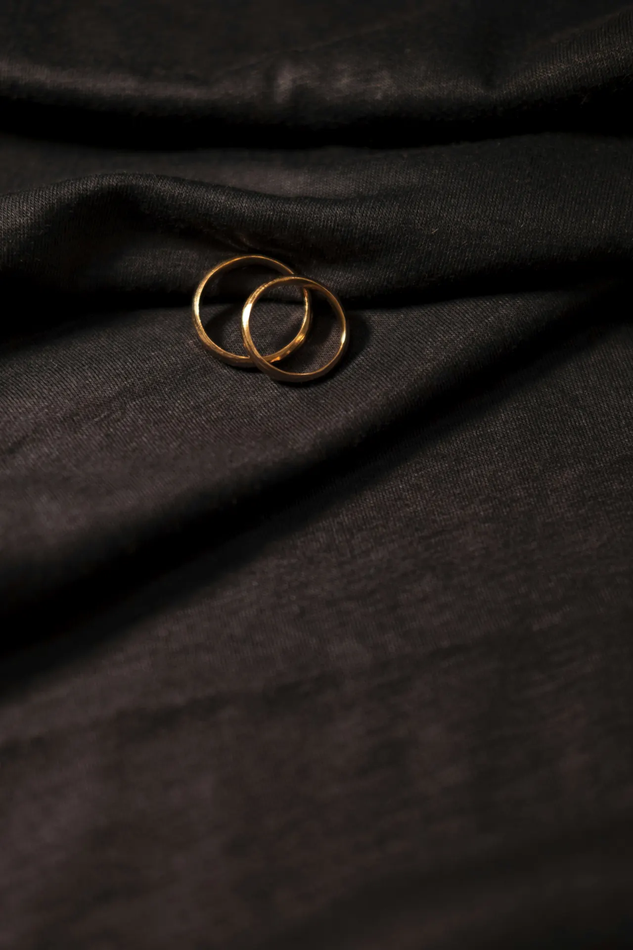 A gold ring resting on black fabric