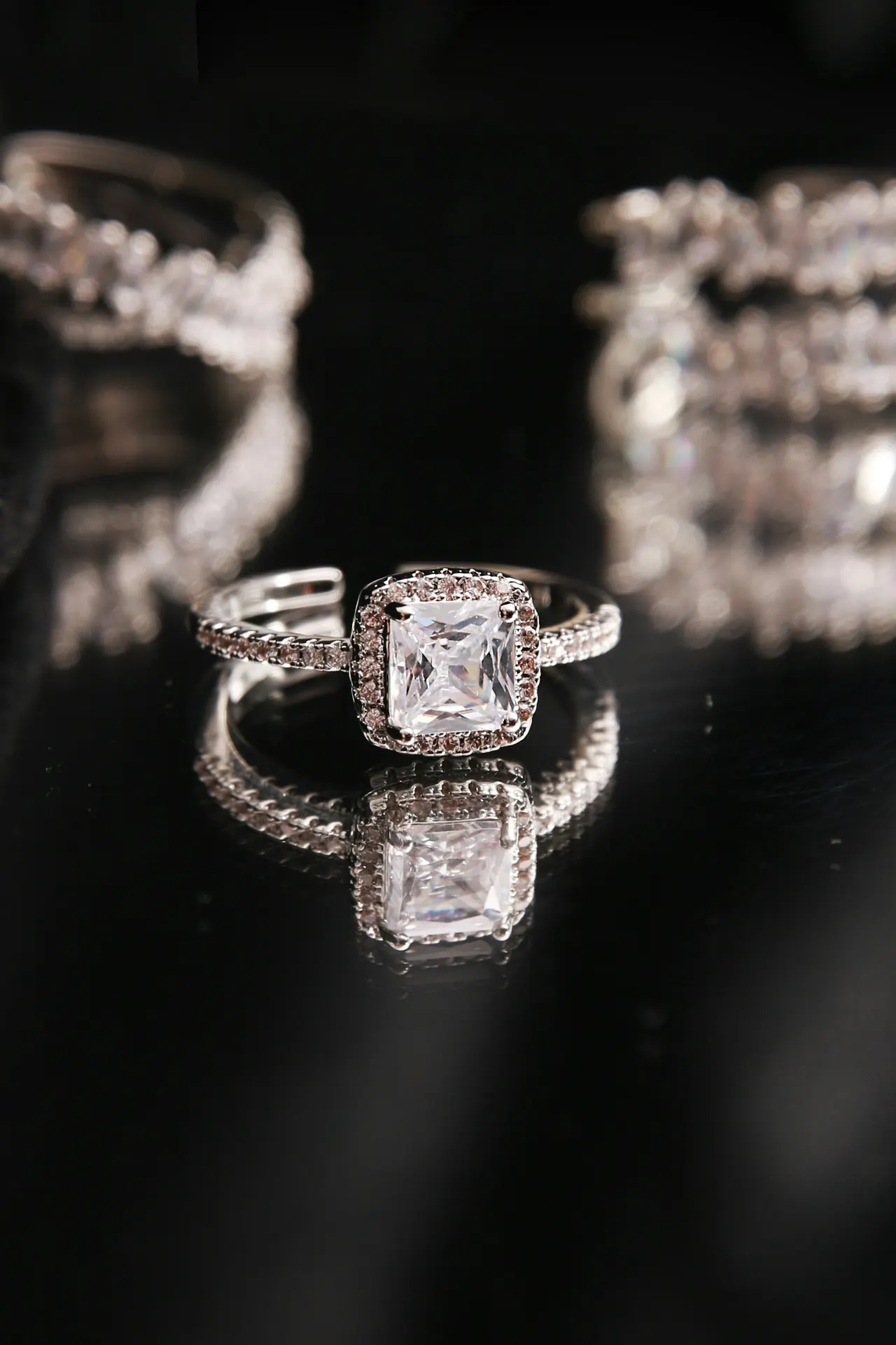 A diamond solitaire ring on a black background